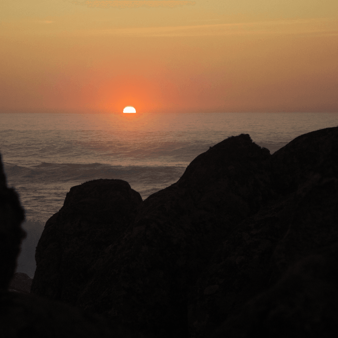 Experience the sunset in Oia, Santorini, renowned for its white buildings and blue domes against the stunning backdrop of the Aegean Sea.